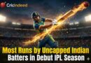 A dynamic, explosive photograph of a male cricketer wearing an Indian flag helmet and a blue and yellow uniform, powerfully hitting a cricket ball that creates a trail of fire and sparks in a packed stadium at dusk. The Cricindeed logo is visible at the top left, and the text "Most Runs by Uncapped Indian Batters in Debut IPL Season" is in a bold title at the bottom.